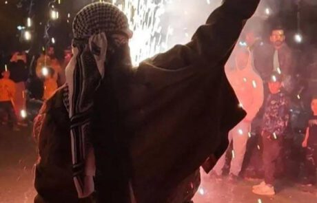 Mujer levantando la mano en señal de victoria, sobre un fondo de manifestación nocturna