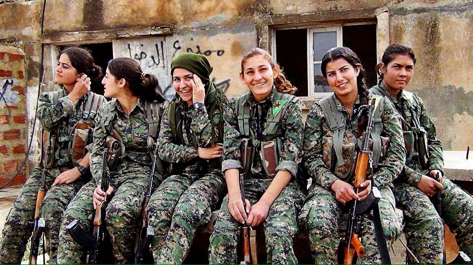 Mujeres combatientes sentadas y sonriendo